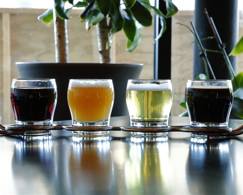 A flight of four beers on the bar
