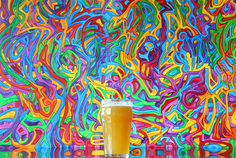 A hazy beer against a vivid painted wall